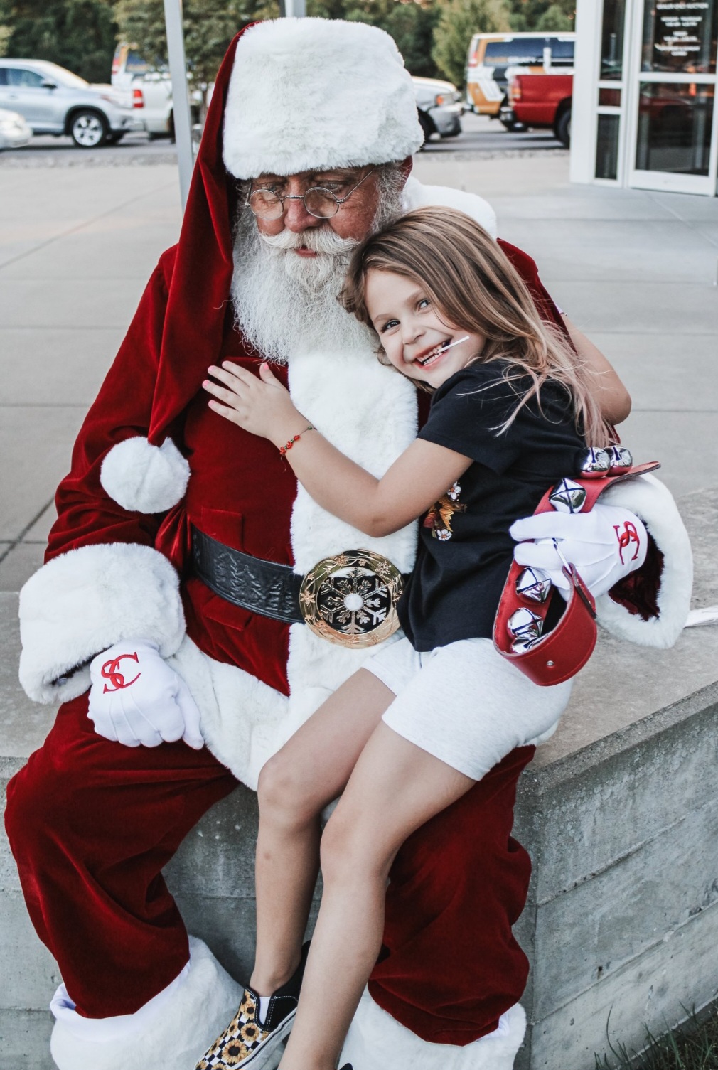 A young person hugging Santa Jim